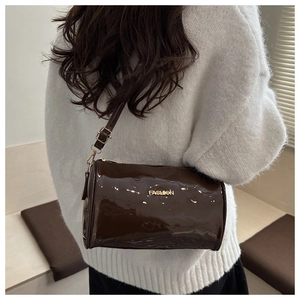 Vue détaillée du sac cylindre marron foncé brillant avec lettrage FASHION en métal