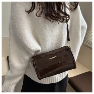 Sac bandoulière cylindre marron brillant avec texte Fashion doré sur un pull en maille