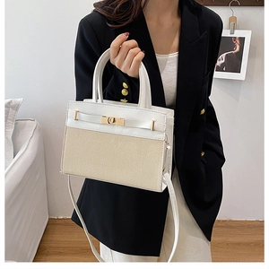 Detail of elegant woven and white leather handbag with golden twist lock and thin strap
