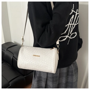 Détail de la texture tressée et du logo de mode sur ce sac bandoulière blanc rond