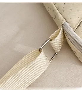 Macro shot of durable metal buckle and star patterned beige fabric on a shoulder bag
