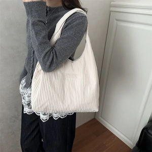 Minimalist white pleated shoulder bag for women with fashion label and textured fabric