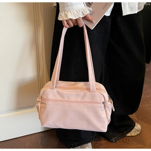 Detail of light pink nylon shoulder bag with multi-pocket design and zip closure