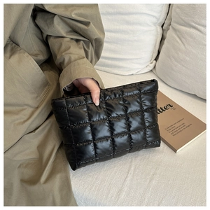 Dettaglio di una pochette trapuntata nera che mostra il tessuto impermeabile e le cuciture