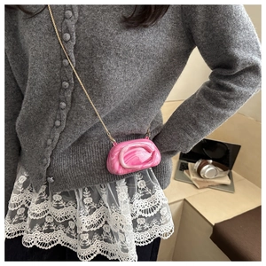 Detailed shot of pink marble texture acrylic bag with elegant golden chain strap