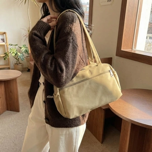 Minimalist beige casual shoulder bag with dual handles and metal zipper exterior pocket