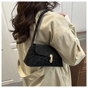 Detail of leopard print underarm bag with gold lock worn with a beige trench coat