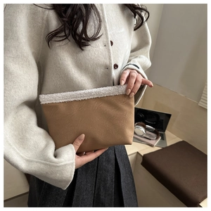 Detail van bruine lederen clutch met witte imitatiebontrand en stijlvolle textuur