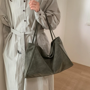 Detail of large olive green matte tote bag with soft texture and slim shoulder straps