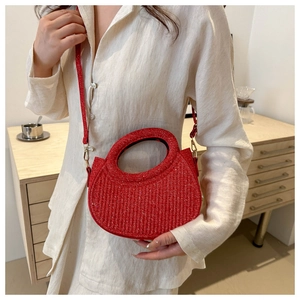 Vue détaillée du sac croissant rouge avec texture scintillante et poignée intégrée