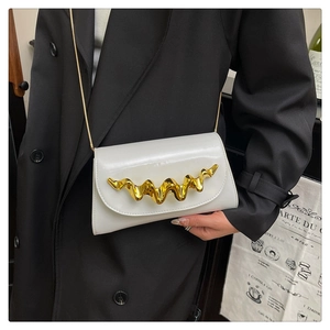 Détail d'une pochette de soirée blanche brillante avec bordure métallique dorée et chaîne