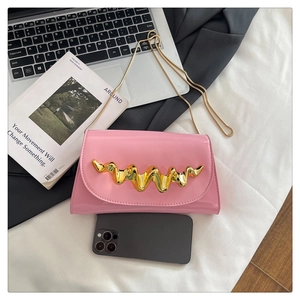 Détail d'un sac bandoulière en cuir verni rose avec boucle dorée et bandoulière chaîne
