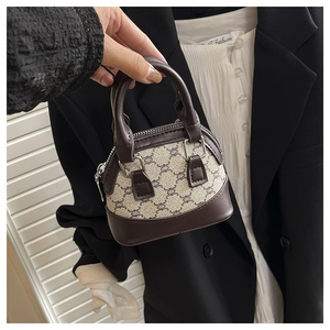Detailed macro view of a mini printed canvas handbag with leather trim and zip closure