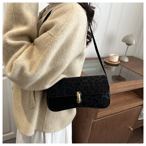 Detail of leopard print shoulder bag with gold clasp shown in a lifestyle interior