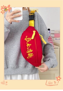 Détail du sac bandoulière en toile rouge avec broderie jaune et sangle ajustable