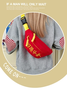 Détail du sac bandoulière en toile rouge avec broderie calligraphique jaune et boucle