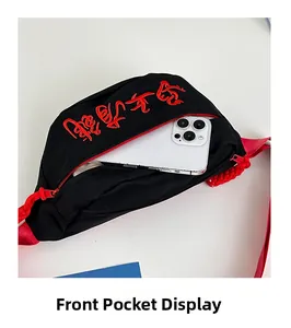 Gros plan de la poche zippée avant sur un sac bandoulière en toile avec broderie rouge