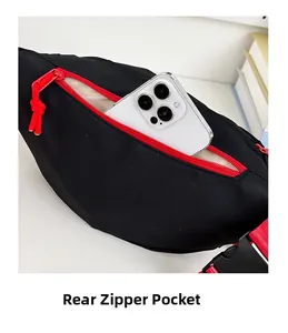 Détail de la poche zippée arrière du sac à bandoulière noir et rouge avec un téléphone