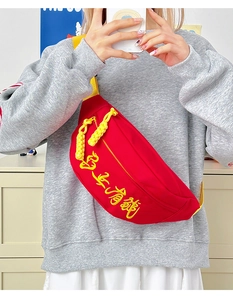 Détail du sac banane rouge avec broderie jaune et bandoulière tissée pour le sport