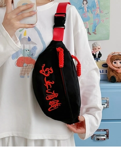 Détail du sac de poitrine noir en toile avec broderie rouge et boucle en plastique robuste