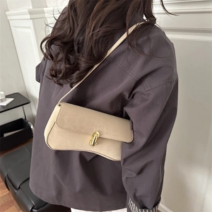 Minimalist beige leopard print crescent shoulder bag with golden cylindrical metal clasp