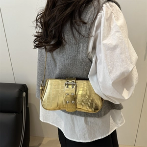 Golden crocodile embossed shoulder bag featuring a bold metal buckle on a rectangular frame