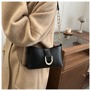 Détail du sac sous l'aisselle en cuir PU mat noir avec boucle métallique en U dorée
