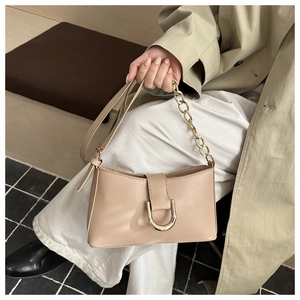 Détail du sac bandoulière en cuir beige avec boucle dorée en U et bandoulière en chaîne