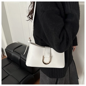 Détail d'un sac à bandoulière en cuir PU blanc avec une boucle métallique dorée en U