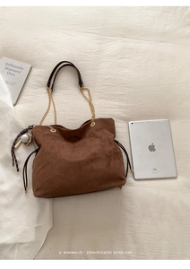 Top view of large brown suede bucket bag with gold chain strap and spacious interior