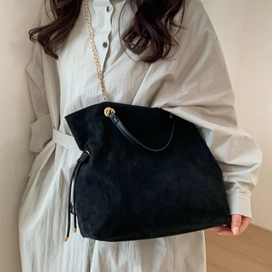 Minimalist black suede bucket bag with gold chain strap and large capacity tote design
