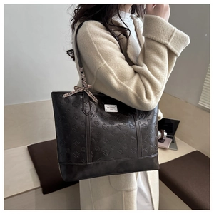 Detail of dark brown tote bag with Bread Cat embossing and fashion ribbon accent