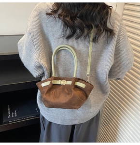 Dettaglio della borsa in pelle scamosciata con volant eleganti e tracolla verde regolabile
