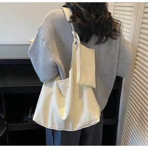 Detail of creamy white large hobo bag with matching pouch and knotted shoulder strap