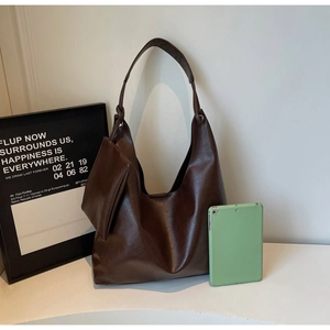 Detail view of large brown hobo tote bag with matching small pouch and thick shoulder strap