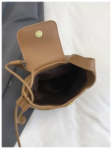 Top view of brown suede bucket bag interior showing spacious drawstring compartment