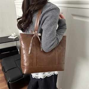 Brown leather tote bag with cat embossed pattern and checkered bow on handle for winter