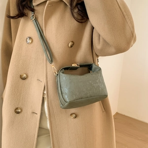 Borsa a tracolla retrò verde salvia con strisce verticali e cinturino su cappotto lana
