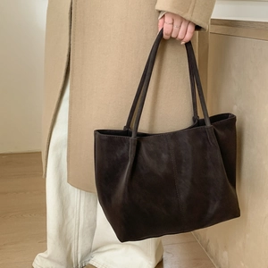 Detail of a large chocolate brown tote bag with soft suede texture and thin shoulder straps
