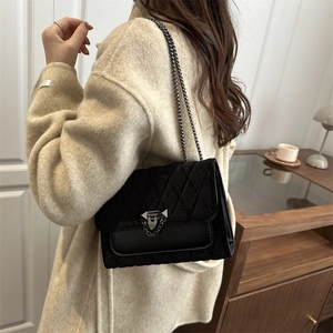 Quilted black chain shoulder bag with minimalist design for a modern stylish winter look