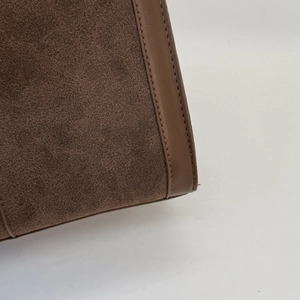 Detail aus dunkelbraunem Wildleder und Ledernähten einer Vintage-Umhängetasche