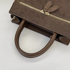 Detail der kaffeebraunen Wildleder-Umhängetasche mit goldenen Doppelreißverschlüssen