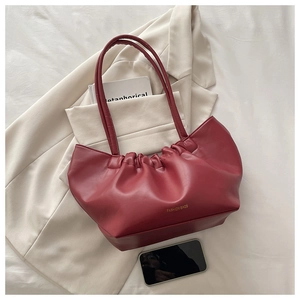 Close-up of red PU leather tote with ruched detail and gold Fashion Bags lettering