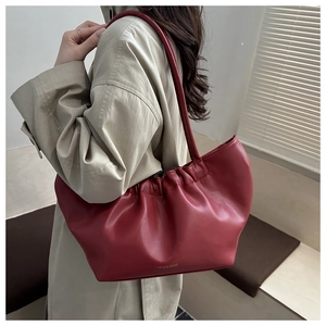 Detailed view of a dark red pleated tote bag with fashion gold foil lettering