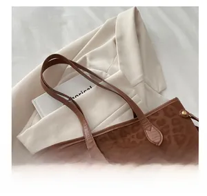 Detail of leopard print tote bag with metallic rivet accents on the handles