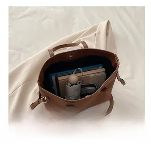 Interior view of brown faux leather tote showing storage for tablet and daily items