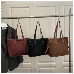 Close-up of leopard print textures on burgundy, black and dark brown tote bags