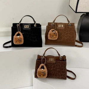 Three leopard print patchwork bucket bags with gold twist locks and plush charms
