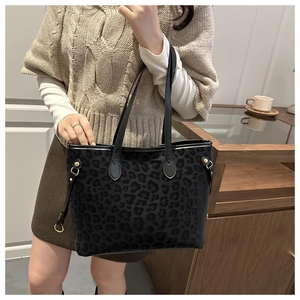 Detail of vintage leopard print tote bag with gold hardware and shoulder straps on model