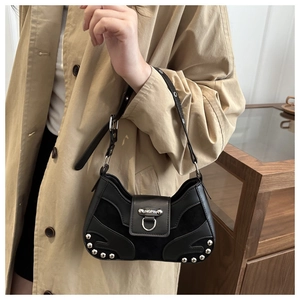 Close-up of black baguette bag with silver rivets and branded metal buckle detail